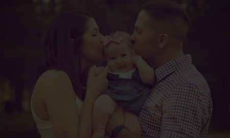 Couple Kissing a Baby with Dark Overlay